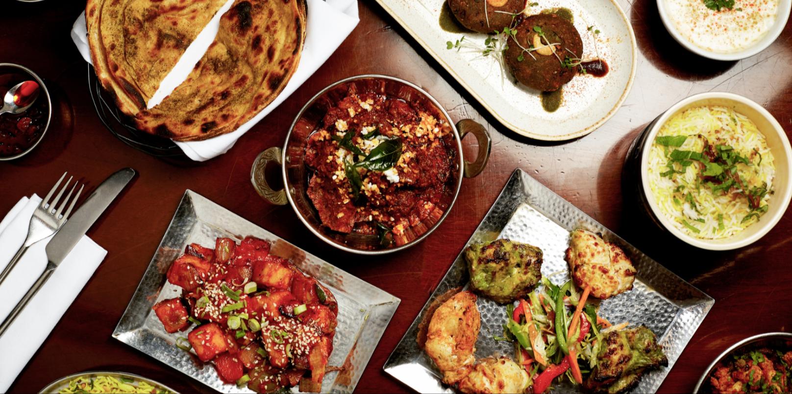 A table of Potli dishes — paratha, curries, tandoori chicken and biryani