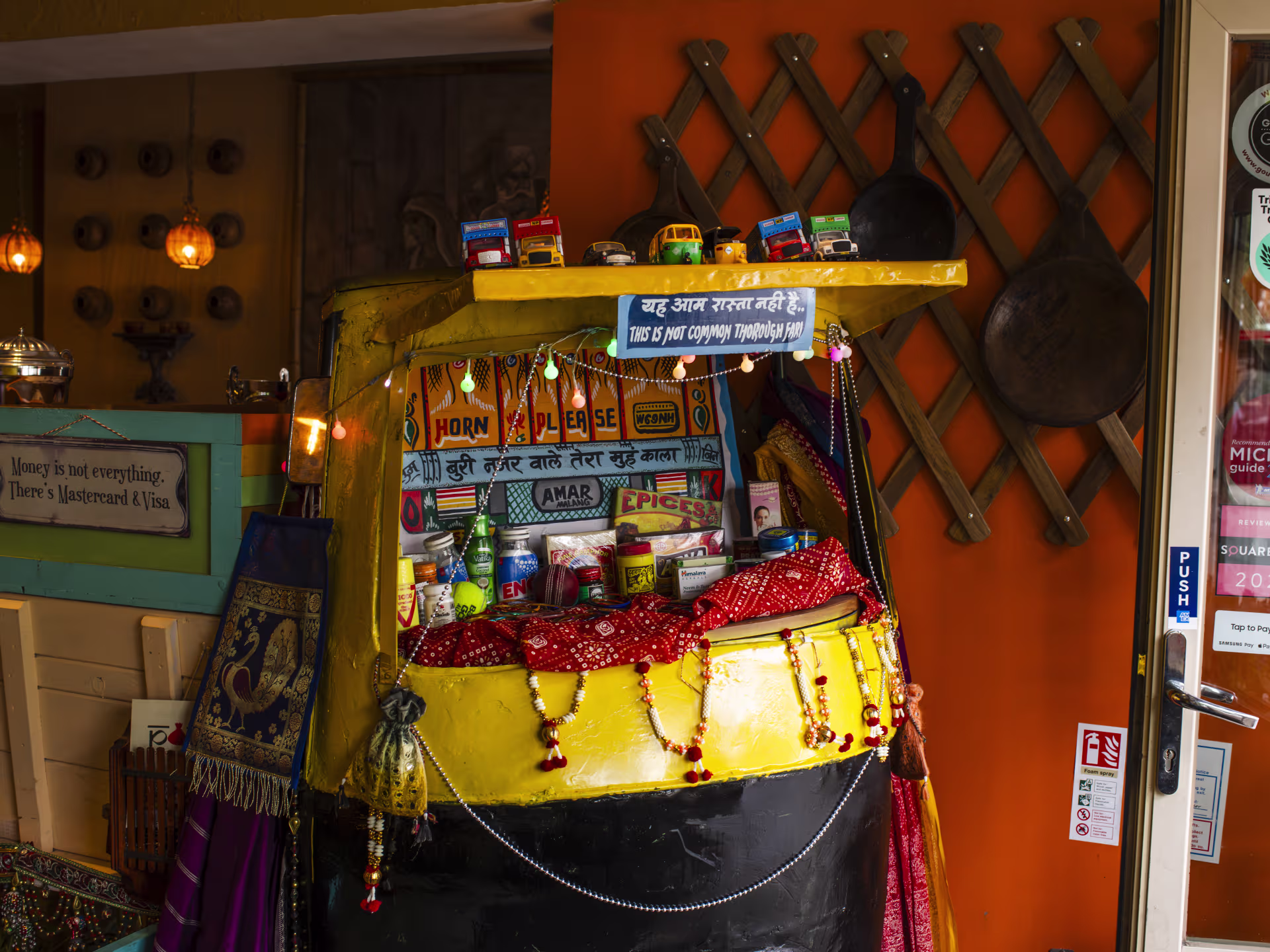 The decorated tuk-tuk stall inside Potli, hung with lights and spice tins